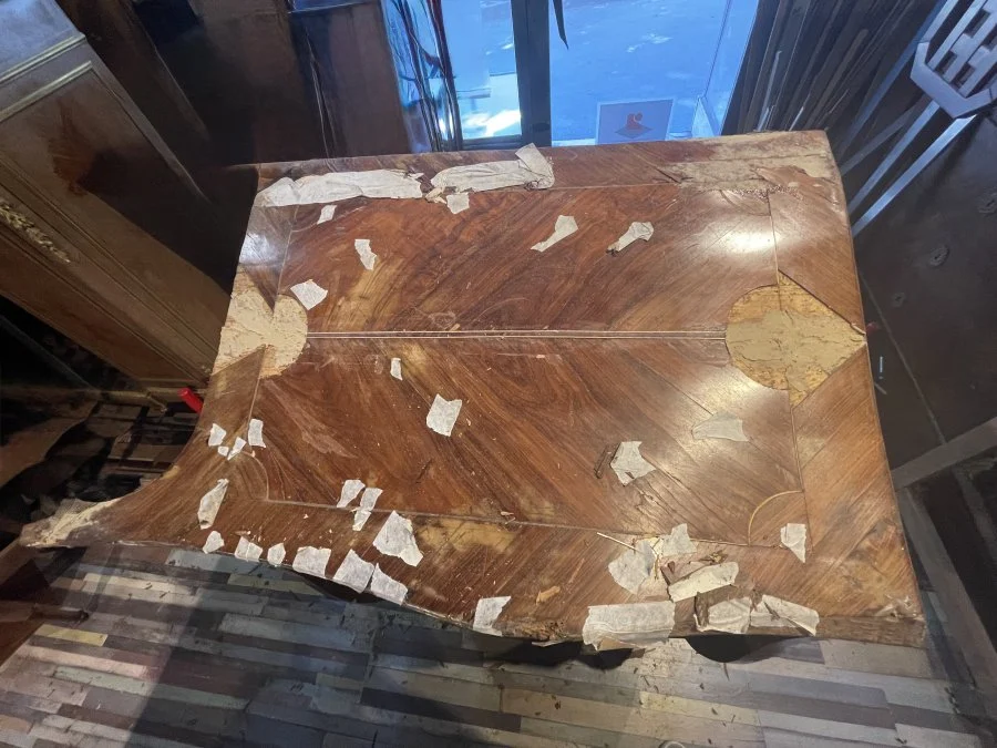 Flanc de commode ancienne au placage abîmé par l'humidité, avant restauration